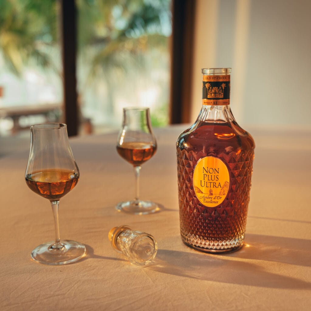 bottle of Old St. Croix Non Plus Ultra Ambre d’Or Excellence on a table with two nosing glasses on the left side